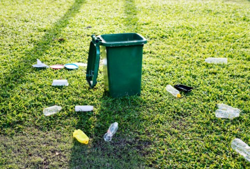 plastic bottles scattered next to trash bin